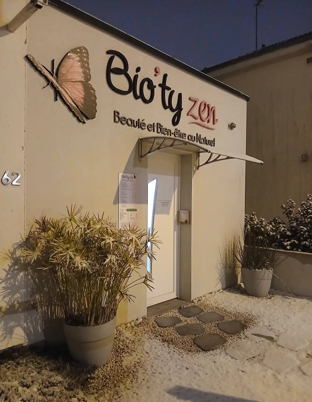 L'entrée de Bio'ty Zen au 62 rue du Docteur Calmette, l'enseigne au papillon éclairée un soir de neige